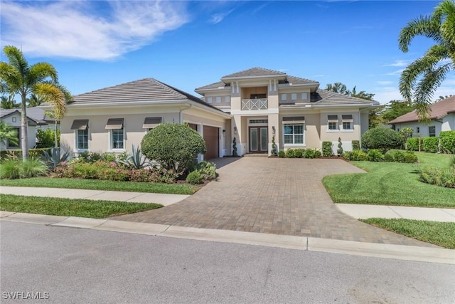 14179 Charthouse Ct, Naples, FL 34114 - prairie-style home featuring a balcony, a garage, decorative driveway, stucco siding, and a front yard