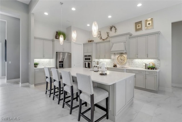 14179 Charthouse Ct, Naples, FL 34114 - kitchen with stainless steel appliances, premium range hood, decorative backsplash, a large island with sink, and a breakfast bar