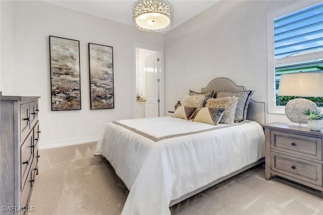 14179 Charthouse Ct, Naples, FL 34114 - bedroom with light colored carpet, ensuite bathroom, and baseboards
