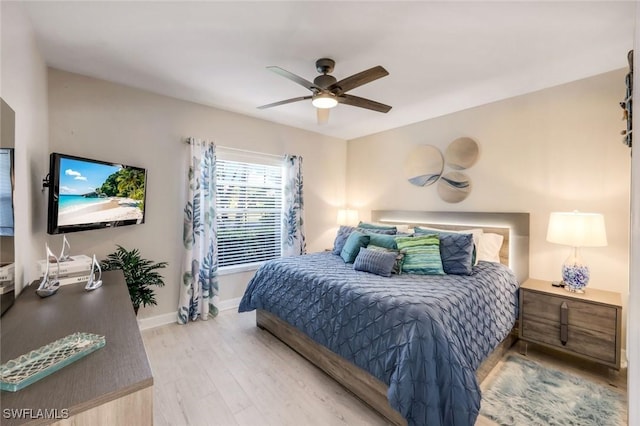 bedroom with light wood-style floors, baseboards, and a ceiling fan