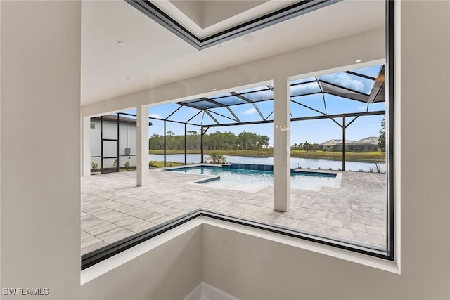 swimming pool featuring a patio area, glass enclosure, and a water view