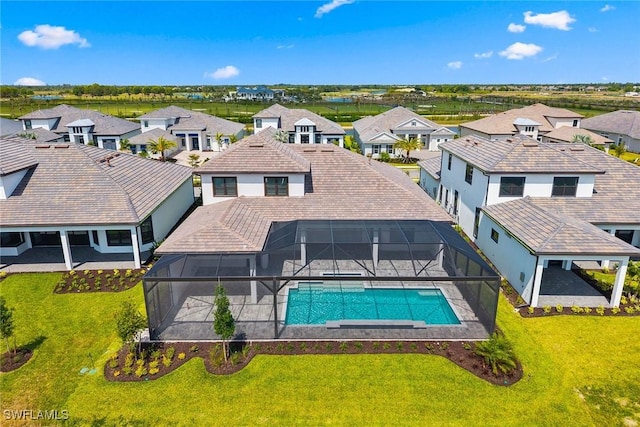 back of property featuring a residential view, an outdoor pool, a patio, and glass enclosure