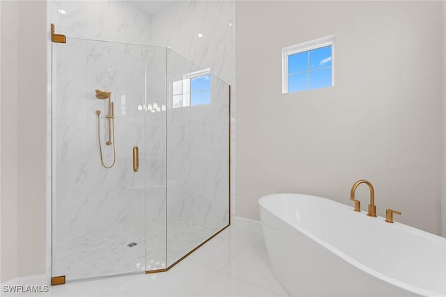 full bath with a marble finish shower, a freestanding tub, baseboards, and tile patterned floors