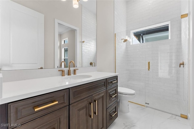 bathroom featuring marble look tile flooring, toilet, a stall shower, and vanity