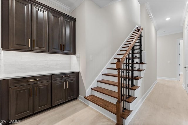 stairway with ornamental molding, baseboards, recessed lighting, and wood finished floors