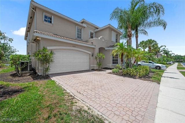 10310 Carolina Willow Dr, Fort Myers, FL 33913 - mediterranean / spanish house featuring decorative driveway, stucco siding, and a garage