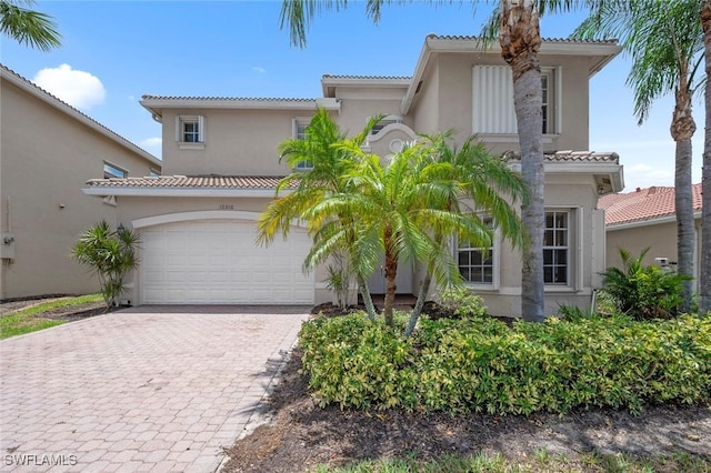 10310 Carolina Willow Dr, Fort Myers, FL 33913 - mediterranean / spanish home with stucco siding, decorative driveway, a tiled roof, and a garage