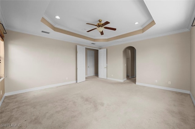 10310 Carolina Willow Dr, Fort Myers, FL 33913 - unfurnished bedroom featuring crown molding, arched walkways, a tray ceiling, recessed lighting, and light carpet