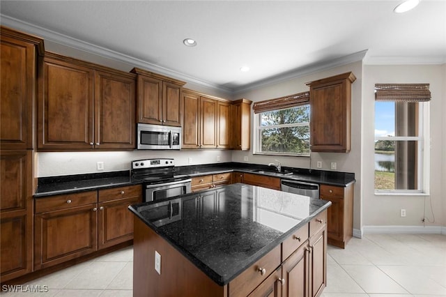 10310 Carolina Willow Dr, Fort Myers, FL 33913 - kitchen with appliances with stainless steel finishes, light tile patterned floors, a sink, ornamental molding, and a kitchen island