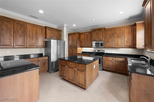 10310 Carolina Willow Dr, Fort Myers, FL 33913 - kitchen featuring appliances with stainless steel finishes, ornamental molding, a sink, dark stone counters, and a center island