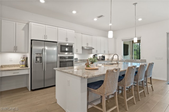 14860 Cherry Blossom Way, Punta Gorda, FL 33955 - kitchen with stainless steel appliances, a sink, under cabinet range hood, white cabinets, and recessed lighting