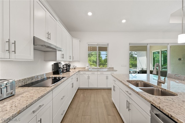 14860 Cherry Blossom Way, Punta Gorda, FL 33955 - kitchen featuring black electric cooktop, a sink, under cabinet range hood, white cabinets, and light wood-style floors