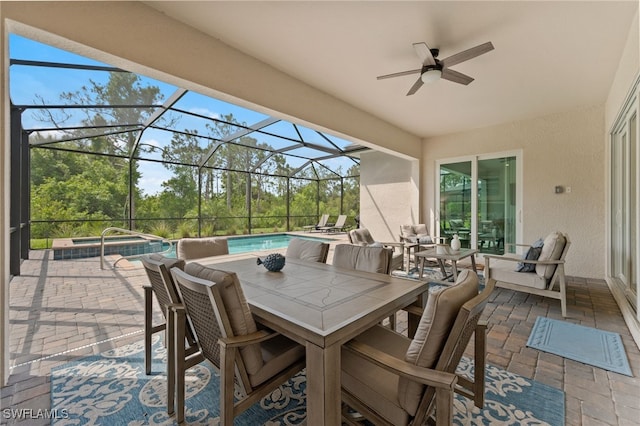 14860 Cherry Blossom Way, Punta Gorda, FL 33955 - view of patio featuring a ceiling fan, outdoor dining area, glass enclosure, view of scattered trees, and a pool with connected hot tub