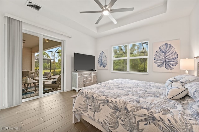 14860 Cherry Blossom Way, Punta Gorda, FL 33955 - bedroom featuring access to outside, a tray ceiling, wood finished floors, ceiling fan, and baseboards