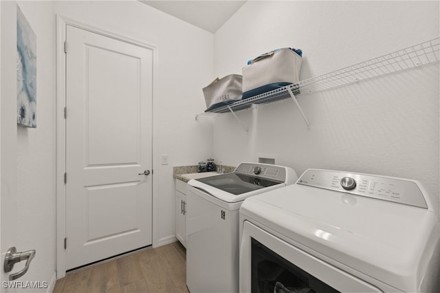 14860 Cherry Blossom Way, Punta Gorda, FL 33955 - laundry room with independent washer and dryer, cabinet space, and light wood finished floors