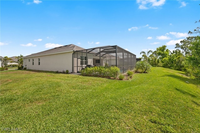 14860 Cherry Blossom Way, Punta Gorda, FL 33955 - rear view of house featuring a lawn, stucco siding, and glass enclosure