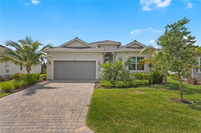 14860 Cherry Blossom Way, Punta Gorda, FL 33955 - view of front facade featuring decorative driveway, a front yard, an attached garage, and stucco siding