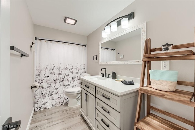 114 Lovers Ln, Fort Myers Beach, FL 33931 - bathroom featuring wood finished floors, toilet, vanity, and baseboards