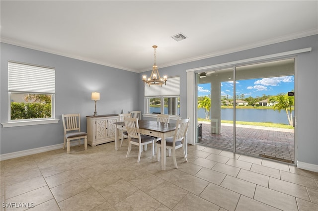 dining space with plenty of natural light, ornamental molding, a chandelier, a water view, and baseboards