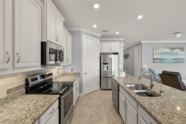 kitchen featuring appliances with stainless steel finishes, a sink, white cabinetry, crown molding, and tasteful backsplash