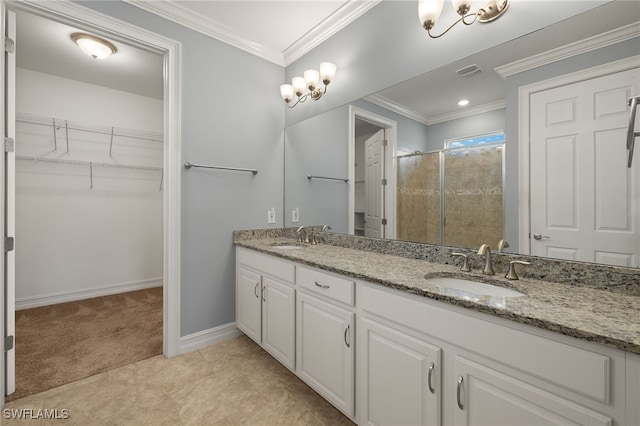 bathroom featuring a shower stall, double vanity, a walk in closet, crown molding, and baseboards