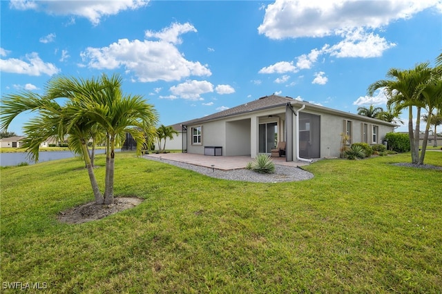 rear view of property featuring a patio area, stucco siding, a yard, and a water view