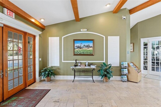 foyer entrance featuring french doors, stone tile floors, and baseboards