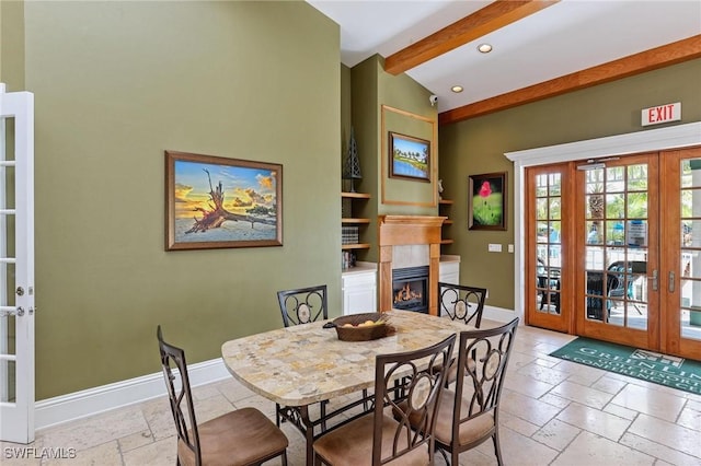 dining room with french doors, stone tile floors, a lit fireplace, baseboards, and recessed lighting