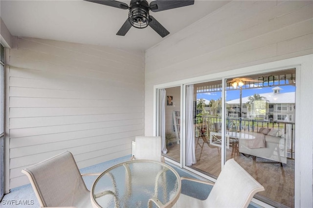 unfurnished sunroom with a ceiling fan and outdoor dining space