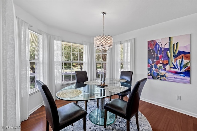 dining space with baseboards, wood finished floors, and a chandelier