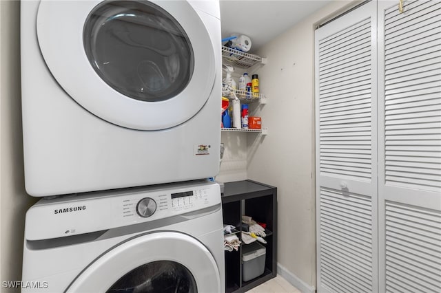 clothes washing area with stacked washer / dryer and baseboards