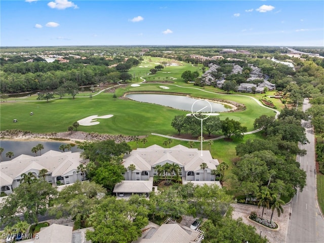aerial view of residential area with a large body of water, a golf course, and a tree filled landscape
