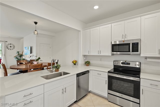 2780 Blossom Way, Naples, FL 34120 - kitchen with appliances with stainless steel finishes, a sink, a peninsula, white cabinetry, and light countertops