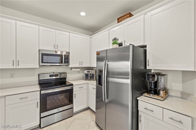 2780 Blossom Way, Naples, FL 34120 - kitchen with stainless steel appliances, white cabinets, light countertops, light tile patterned floors, and recessed lighting