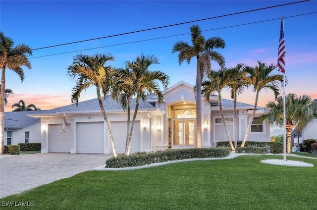 1428 SW 52nd Ln, Cape Coral, FL 33914 - single story home with stucco siding, a lawn, an attached garage, and decorative driveway