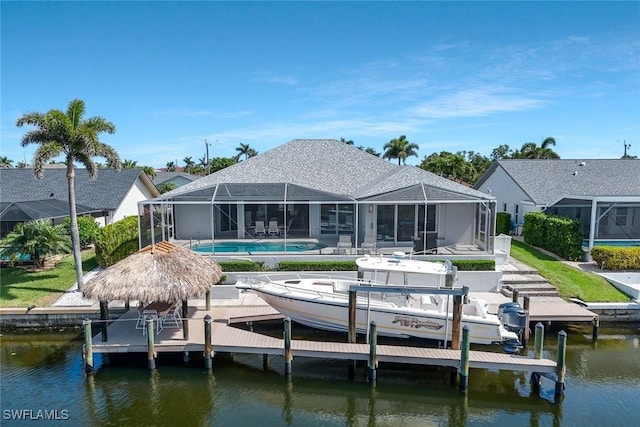 1428 SW 52nd Ln, Cape Coral, FL 33914 - back of house with boat lift, a water view, an outdoor pool, and a patio