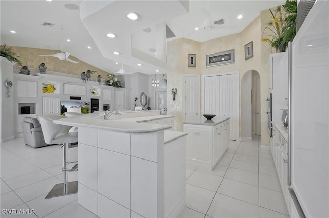 1428 SW 52nd Ln, Cape Coral, FL 33914 - kitchen featuring high vaulted ceiling, a large island, light tile patterned floors, open floor plan, and arched walkways