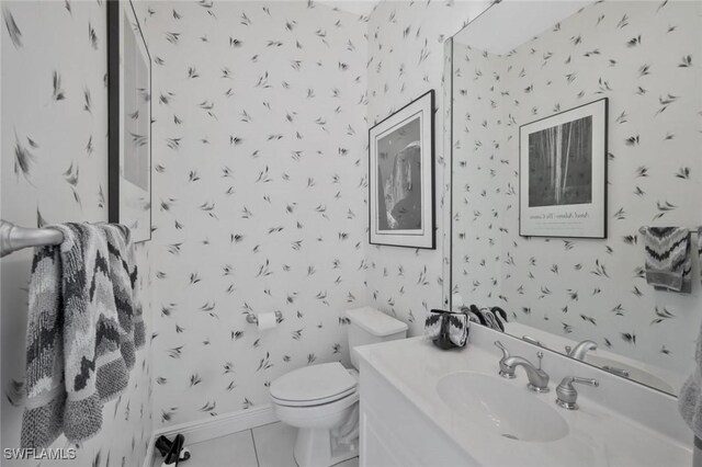 1428 SW 52nd Ln, Cape Coral, FL 33914 - bathroom featuring wallpapered walls, toilet, vanity, tile patterned floors, and baseboards