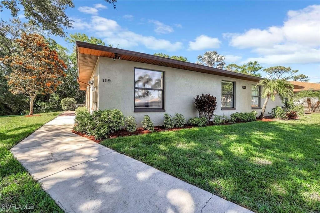10967 Leitner Creek Dr Unit 119, Bonita Springs, FL 34135 - view of front of property with stucco siding and a front yard