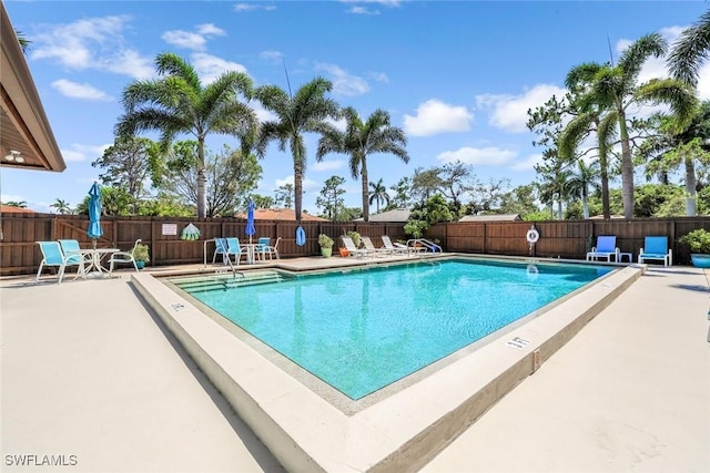 community pool with fence and a patio
