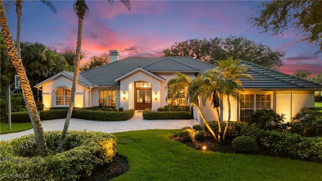 11730 Rosemount Dr, Fort Myers, FL 33913 - ranch-style home featuring french doors, a chimney, a yard, a tile roof, and stucco siding