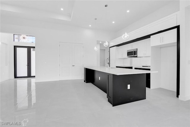 1432 Euclid Ave, Lehigh Acres, FL 33972 - kitchen featuring stainless steel microwave, a center island with sink, white cabinetry, light countertops, and recessed lighting