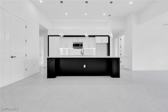 1432 Euclid Ave, Lehigh Acres, FL 33972 - kitchen featuring stainless steel microwave, white cabinets, a large island, light countertops, and recessed lighting