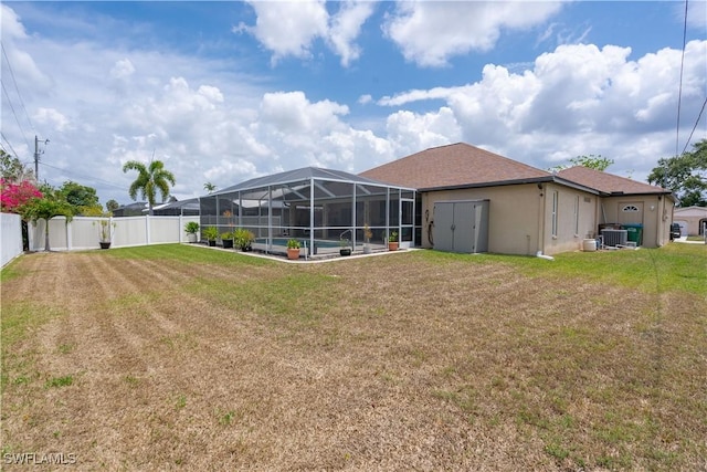view of yard featuring glass enclosure, an outdoor pool, a patio, and central air condition unit
