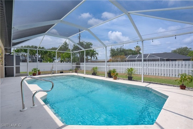 view of pool featuring a fenced backyard, a patio area, and glass enclosure