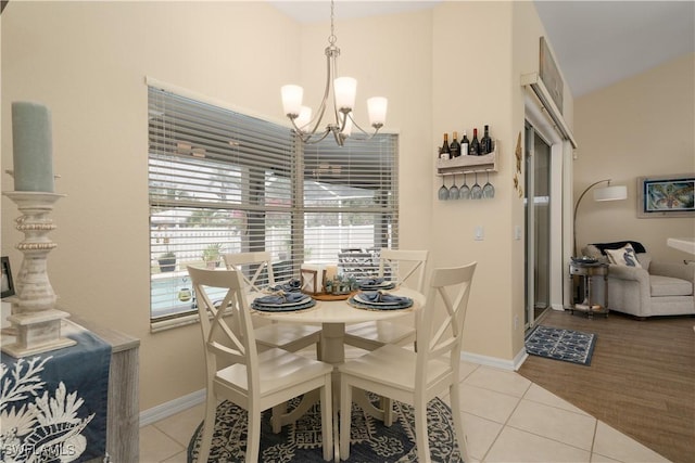 dining area featuring a chandelier, tile patterned flooring, and baseboards