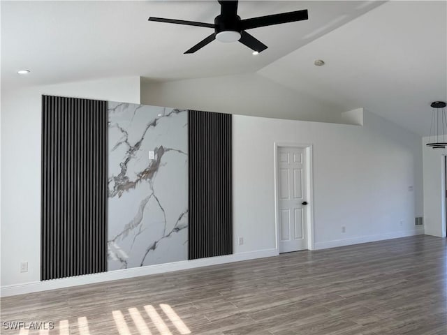 unfurnished room with a ceiling fan, wood finished floors, vaulted ceiling, and baseboards