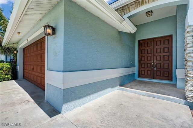 1976 San Marco Rd, Marco Island, FL 34145 - property entrance featuring a garage and stucco siding