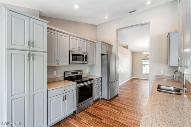 1976 San Marco Rd, Marco Island, FL 34145 - kitchen with stainless steel appliances, vaulted ceiling, gray cabinets, light wood-type flooring, and recessed lighting