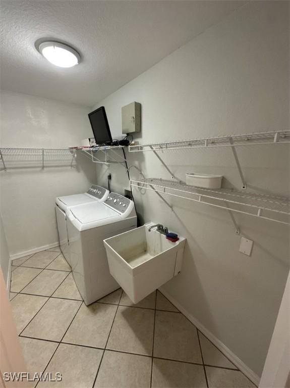 2400 Leavitt Rd, Alva, FL 33920 - laundry area with independent washer and dryer, light tile patterned floors, and baseboards